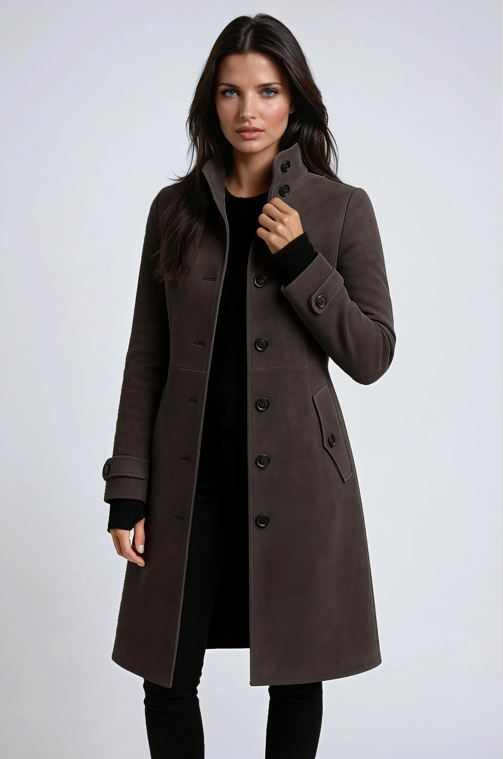 Front view of a taupe brown coat with high buttoned collar, tailored waist and flap pocket, styled with black trousers