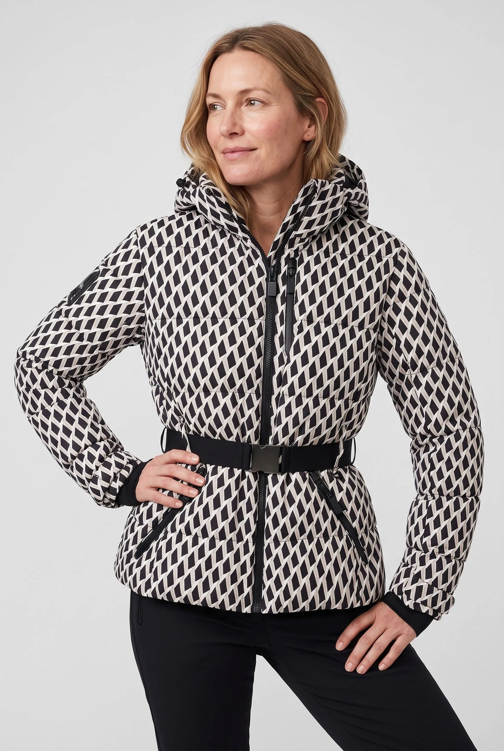 Woman wearing a black and cream geometric print hooded puffer jacket with belted waist