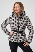 Woman wearing a black and cream geometric print hooded puffer jacket with belted waist