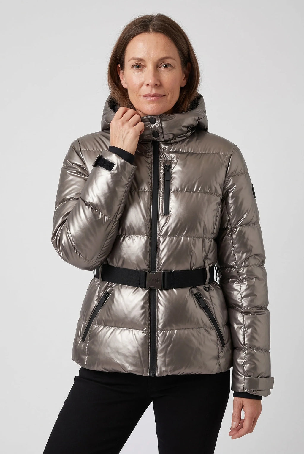 Woman wearing a metallic pewter hooded puffer jacket with touch-fasten cuff tab and belted waist