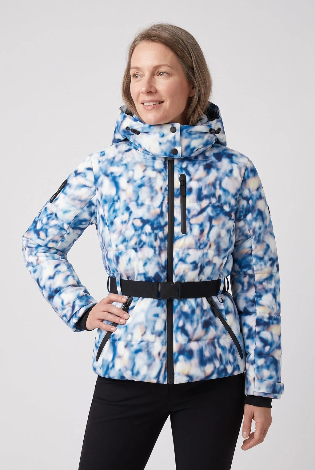 Woman wearing a blue and white abstract print hooded puffer jacket with belted waist