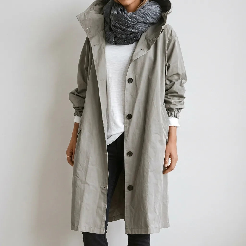 Light grey hooded raincoat buttoned up with a knitted scarf, front pocket and elasticated cuff visible on the sleeve