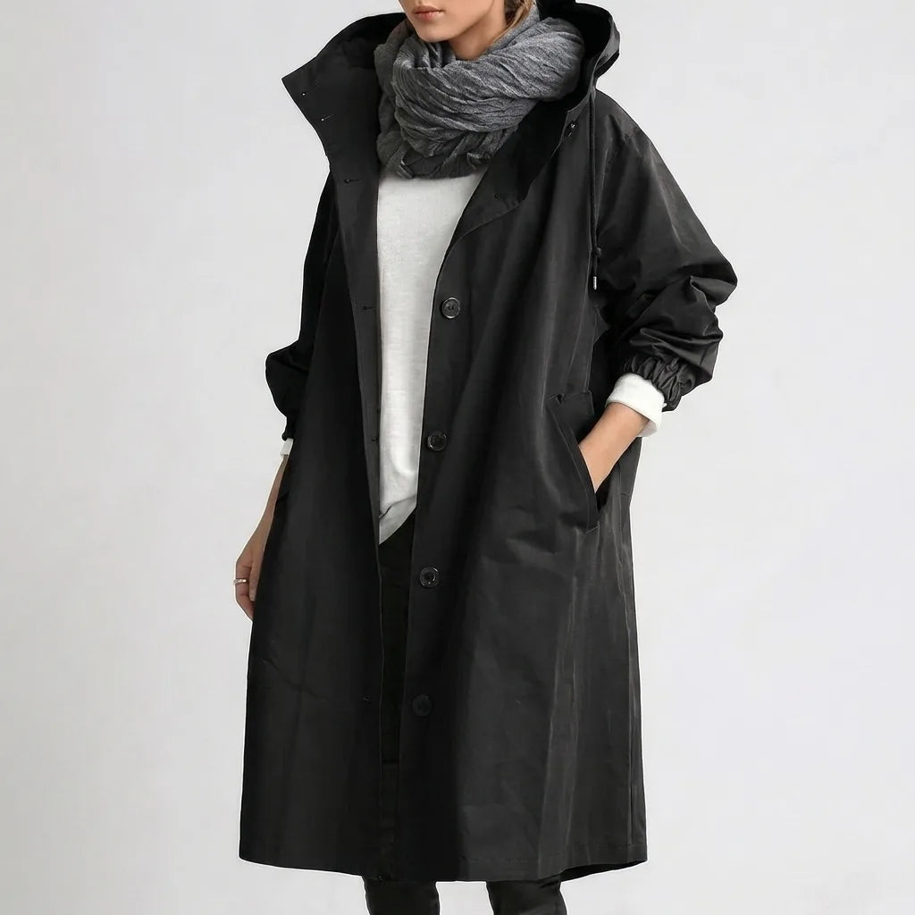 Black hooded raincoat worn open, close view of the drawstring hood toggle and front button fastening