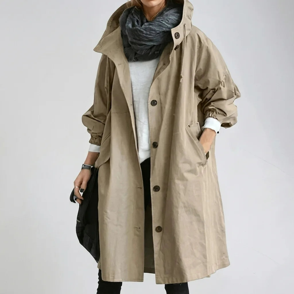 Khaki hooded raincoat with hood drawstring pulled to one side, showing the slash pocket and long below-knee hem
