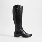 Side profile of a black knee-high leather boot with a tab-and-stud detail at the top and a low stacked heel