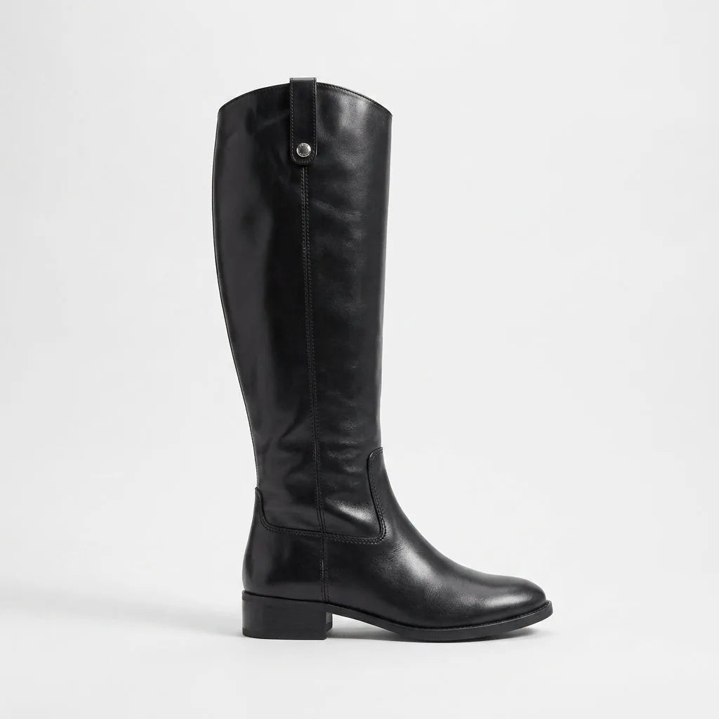 Side profile of a black knee-high leather boot with a tab-and-stud detail at the top and a low stacked heel