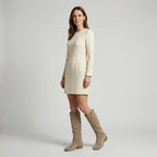 Model wearing a cream long-sleeve mini dress with taupe suede-look knee-high boots, side view