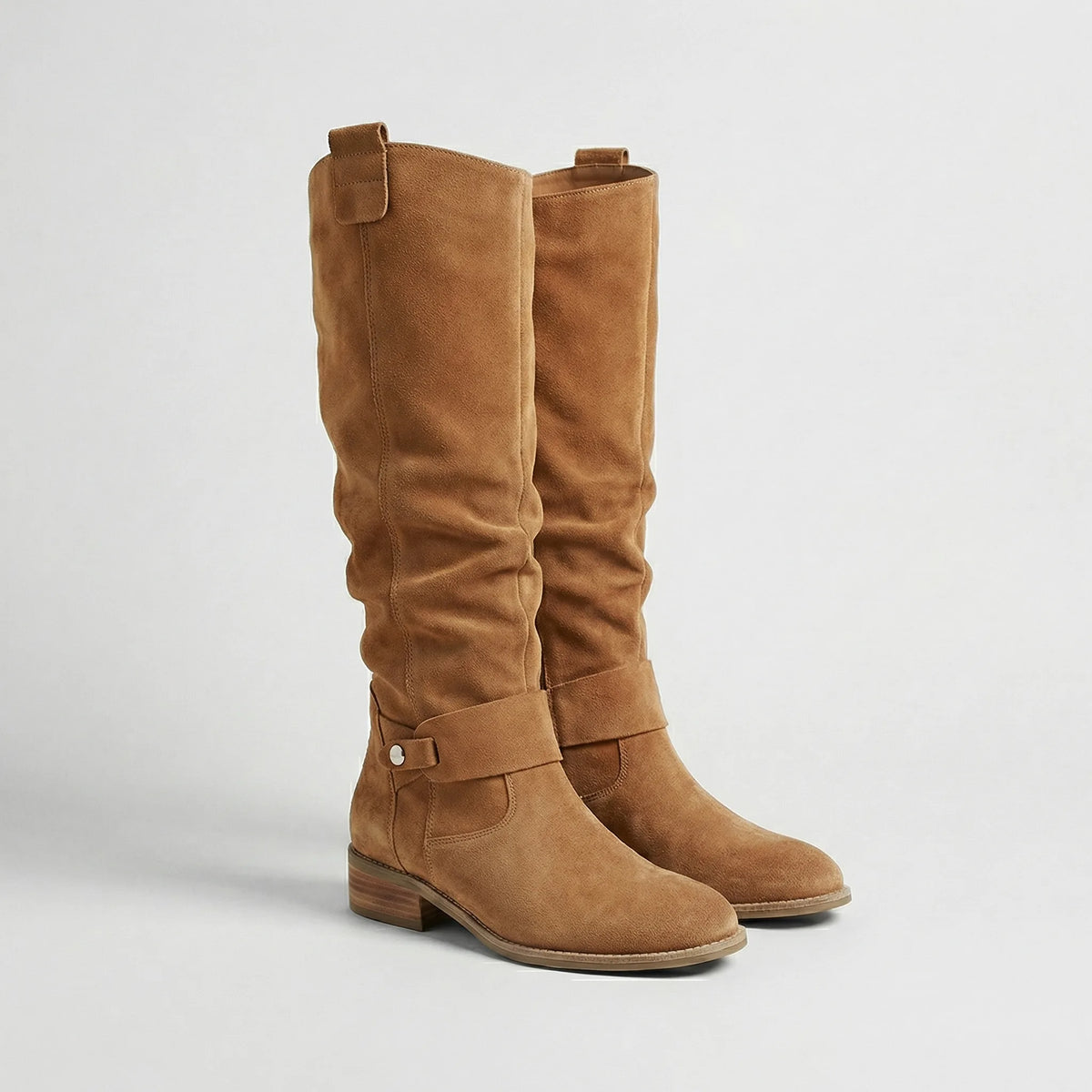 Pair of light brown suede-look knee-high boots with slouchy silhouette, ankle strap and low heel, front angle