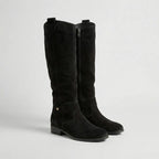 Pair of black suede-look knee-high boots with side zip, buckle strap and low block heel, front angle