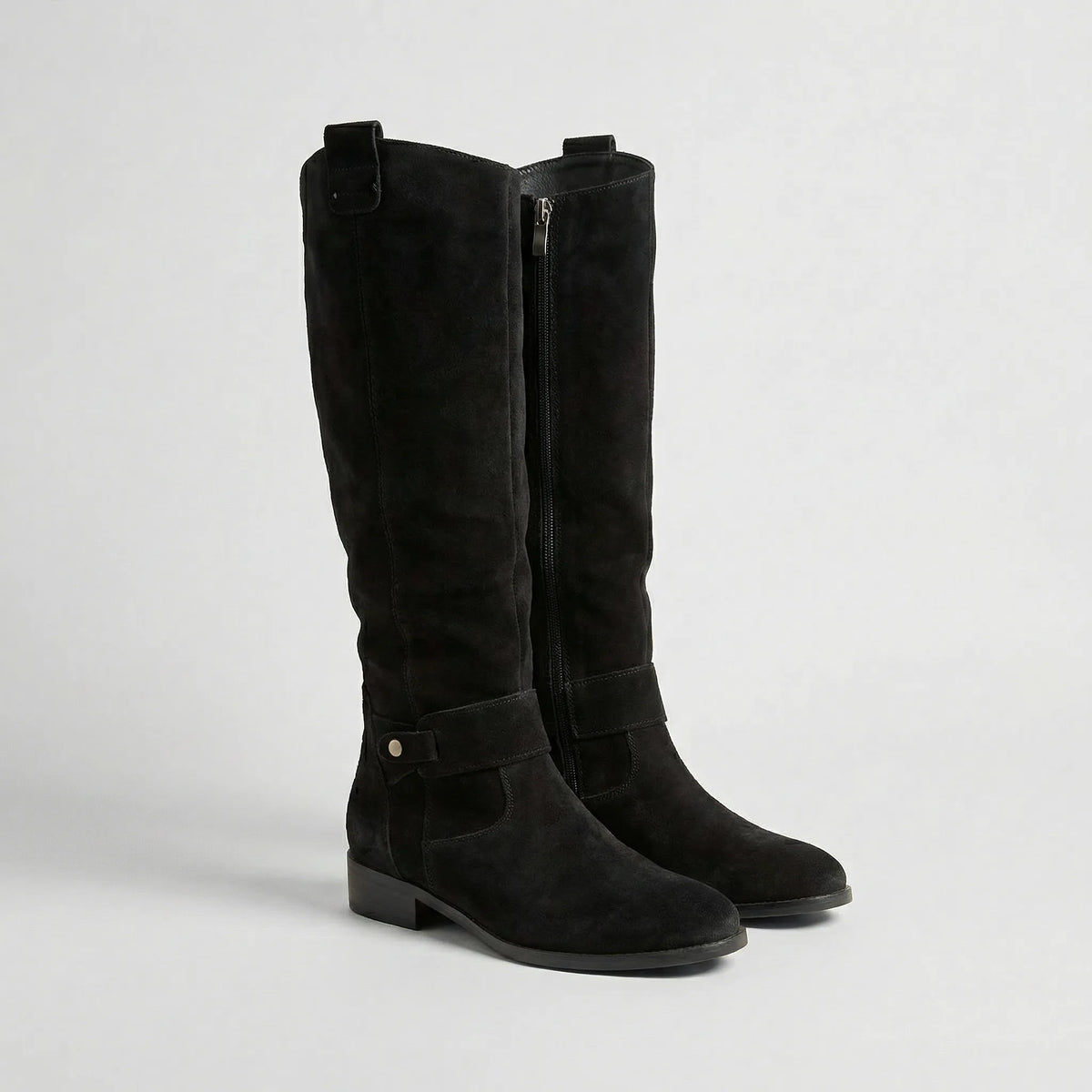 Pair of black suede-look knee-high boots with side zip, buckle strap and low block heel, front angle