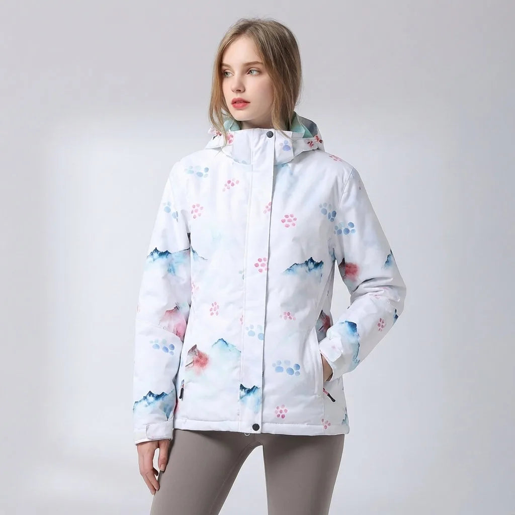 White hooded jacket with a watercolour mountain and pink dot print, hood up and hands in pockets