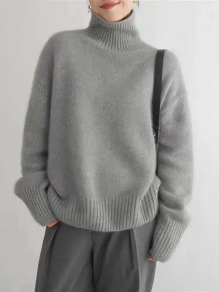 Front close-up of a grey ribbed polo neck jumper paired with matching grey tailored trousers