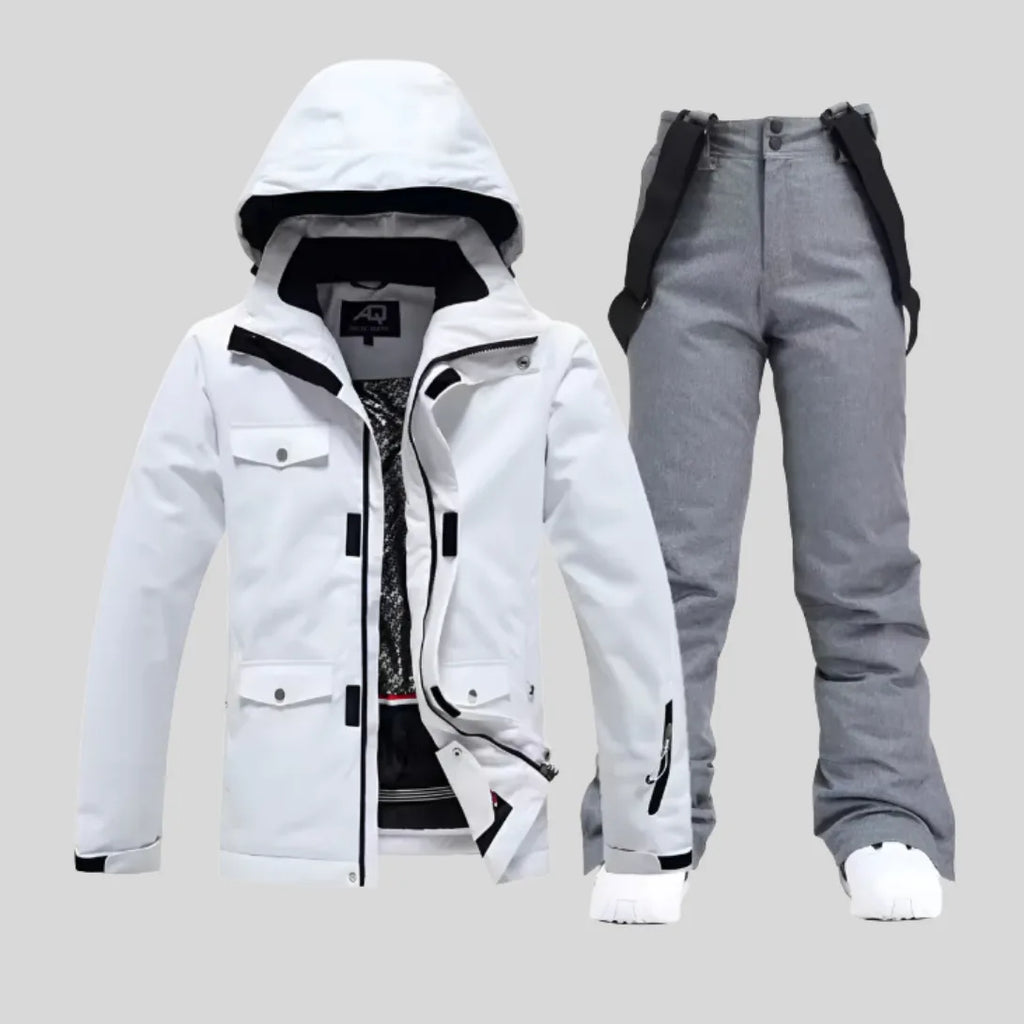 White ski jacket paired with contrasting black bib trousers and white trainers