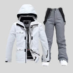 White ski jacket paired with contrasting black bib trousers and white trainers
