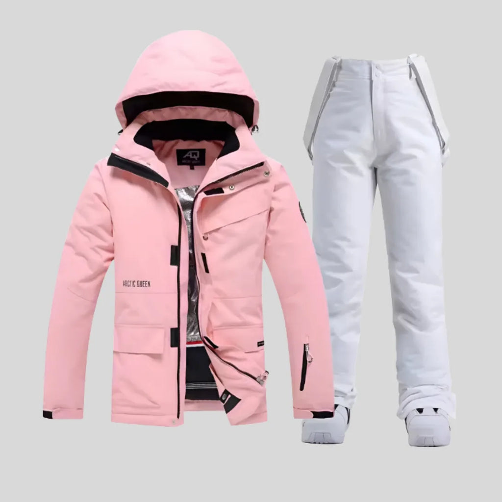 Pink hooded ski jacket with contrasting black bib trousers and white trainers