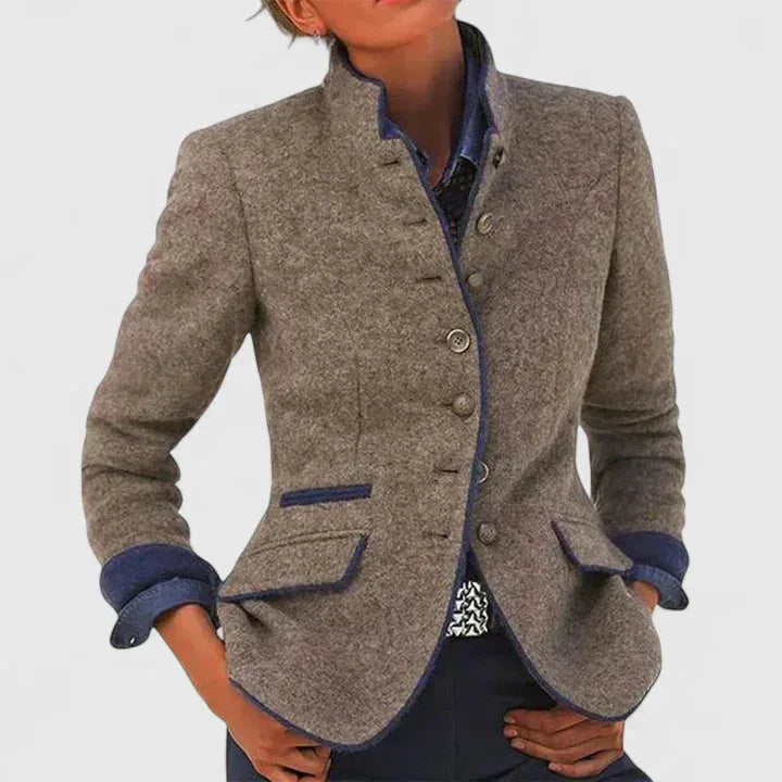 Grey wool-blend blazer with stand collar, navy trim and contrast turned-back cuffs worn with dark trousers