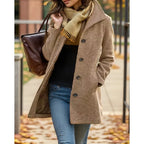 Close-up of khaki brown tailored coat showing turndown collar, button placket and side pocket, worn with a mustard scarf