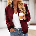 Close-up front view of a burgundy zip-up bomber jacket worn open over a white top, showing satin-look fabric sheen